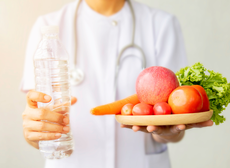 A nutritionist holding a plate of fruits and a bottle of water